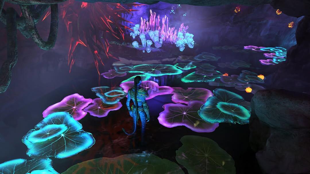 Na'vi character standing in a cave in water at night, so the lilly pads floating are glowing green, blue and purples. While mushrooms are glowing, grass is glowing.